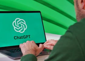 Person typing on a laptop displaying ChatGPT logo with a green vibrant setting.